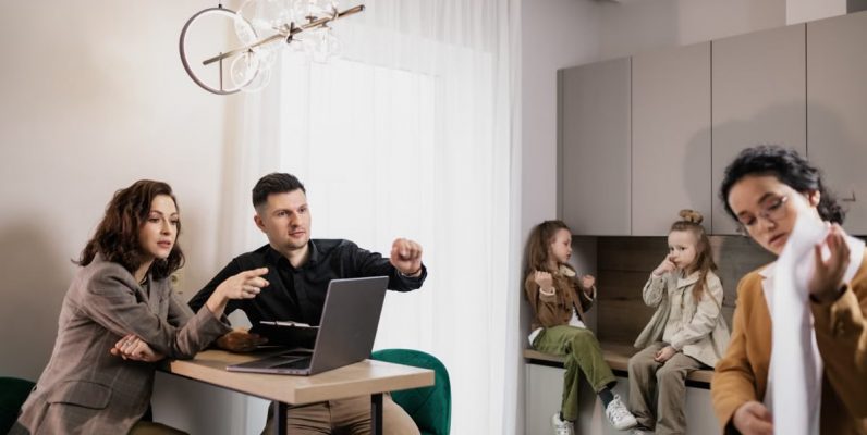 Family discussing real estate purchase inside home with agent and children present.